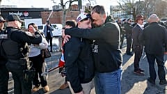 Pawtucket'taki arenanın dışında bir baba, oğluna sarılırken.