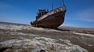 A fishing boat lies stranded on the desertified remains of the Aral Sea.
