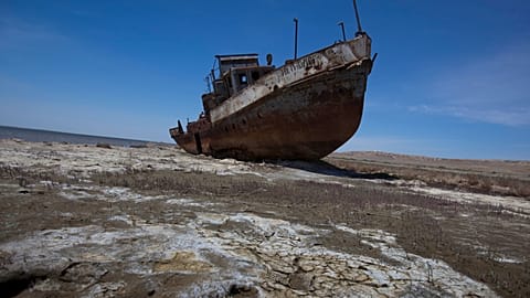 A fishing boat lies stranded on the desertified remains of the Aral Sea.