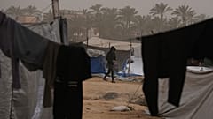 شاب فلسطيني يسير في مخيم مؤقت للنازحين، خلال عاصفة ترابية في منطقة الزوايدة وسط قطاع غزة، السبت 14 فبراير/شباط 2026.