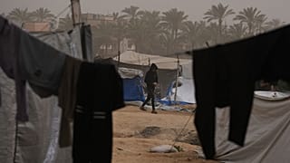 شاب فلسطيني يسير في مخيم مؤقت للنازحين، خلال عاصفة ترابية في منطقة الزوايدة وسط قطاع غزة، السبت 14 فبراير/شباط 2026.