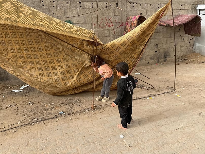 طفلان يلعبان قرب خيمة النزوح