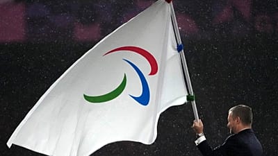 Andrew Parsons, président du Comité international paralympique, avec le drapeau paralympique à Paris Jeux de 2024