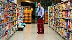 Une personne analyse les prix dans les rayons d'un Carrefour à Dubaï.