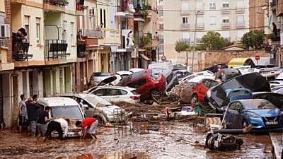 Anwohner betrachten in Valencia zusammengeschobene Autos, die die Flut am Mittwoch, 30. Oktober 2024, mitgerissen hat.