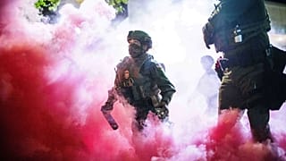 Policías y agentes federales lanzan botes de gas para dispersar a manifestantes cerca de unas instalaciones del Servicio de Inmigración y Control de Aduanas de Estados Unidos en Portland, Oregón, el 5 de octubre de 2025. 