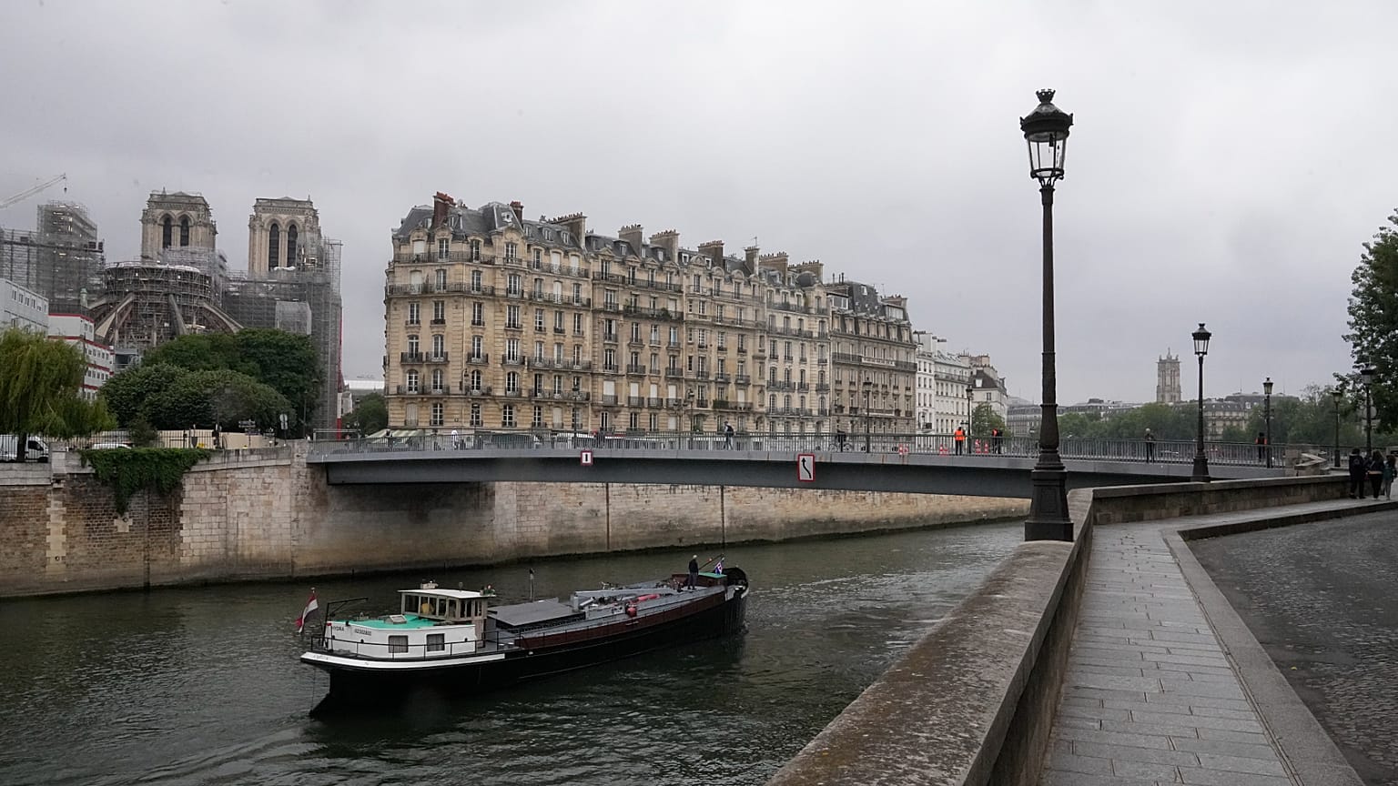 كاتدرائية نوتردام، على اليسار، ومبانٍ باريسية تظهر من ضفاف نهر السين، الثلاثاء 23 مايو 2023 في باريس. (صورة من وكالة أسوشيتد برس/ميشيل أويلر)