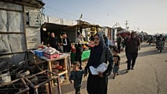 النازحة الفلسطينية كاميليا الزملي تحمل طعامًا لإفطار عائلتها في أول أيام شهر رمضان، في خان يونس بقطاع غزة، الأربعاء 18 فبراير/شباط 2026.