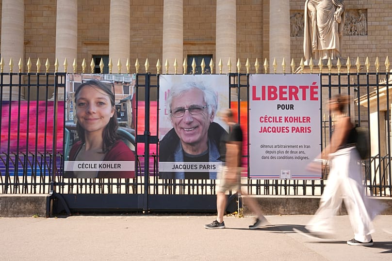 Le portrait de Cécile Kohler et de Jacques Paris sur les grilles de l'Assemblée nationale, le 3 juillet 2025.