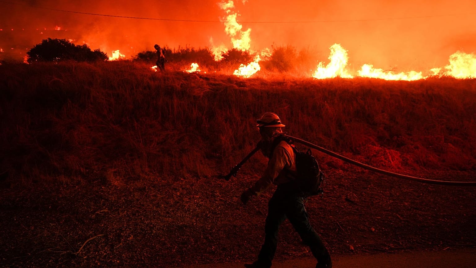 ARCHIVO - Un bombero vigila las llamas provocadas por el incendio Hughes junto al lago Castaic, en Castaic (California), el 22 de enero de 2025.