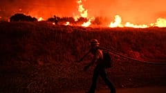 ARCHIV: Ein Feuerwehrmann beobachtet die Flammen des Hughes-Feuers am Castaic Lake in Castaic, Kalifornien, am 22. Januar 2025.