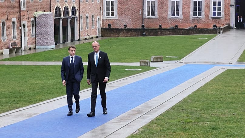 French President Emmanuel Macron, left, and Germany's Chancellor Friedrich Merz arrive for the EU summit at Alden Biesen Castle in Bilzen-Hoeselt, Belgium, Thursday, Feb. 12, 