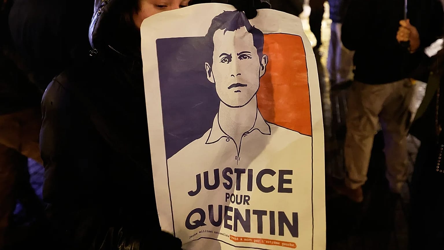A woman holds a placard paying tribute to right-wing student Quentin Deranque in Lille, France 