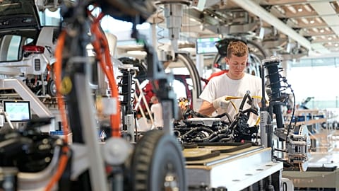 A Volkswagen employee checks an ID.3 electric car at the transparent factory in Dresden, Germany.
