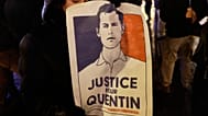 Une femme tient une pancarte sur laquelle on peut lire « Justice pour Quentin » alors qu'elle se rassemble pour rendre hommage à Quentin Deranque lors d'un rassemblement  