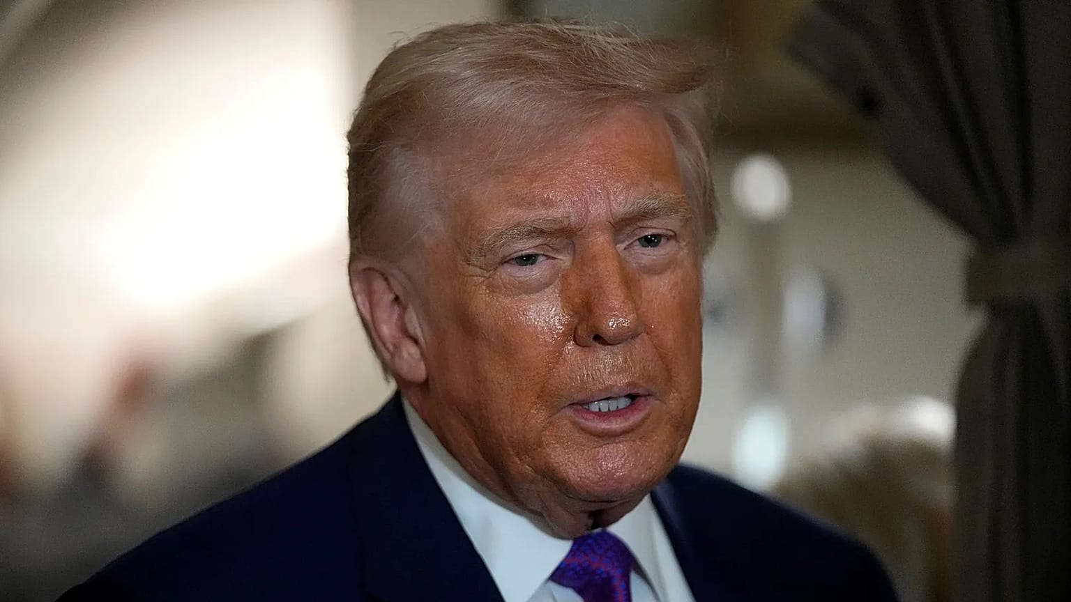 O presidente Donald Trump fala com os jornalistas a bordo do Air Force One pouco antes da descolagem, quinta-feira, 19 de fevereiro de 2026, na Base Conjunta Andrews, Maryland (AP Photo/Mark Schiefelbein)