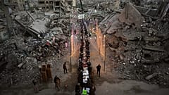 يجلس فلسطينيون حول مائدة طويلة وسط أنقاض مبانٍ مدمّرة، أثناء تجمعهم لتناول وجبة الإفطار، في شهر رمضان، في مدينة خان يونس بقطاع غزة، الخميس 19 فبراير/شباط 2026. 