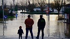Im Département Gironde beobachten Menschen eine überflutete Straße, nachdem heftige Regenfälle den Westen Frankreichs unter Wasser gesetzt haben.