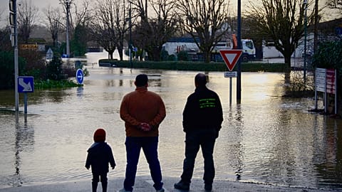 Des habitants observent une rue inondée en Gironde, alors que de fortes crues frappent l'ouest de la France.