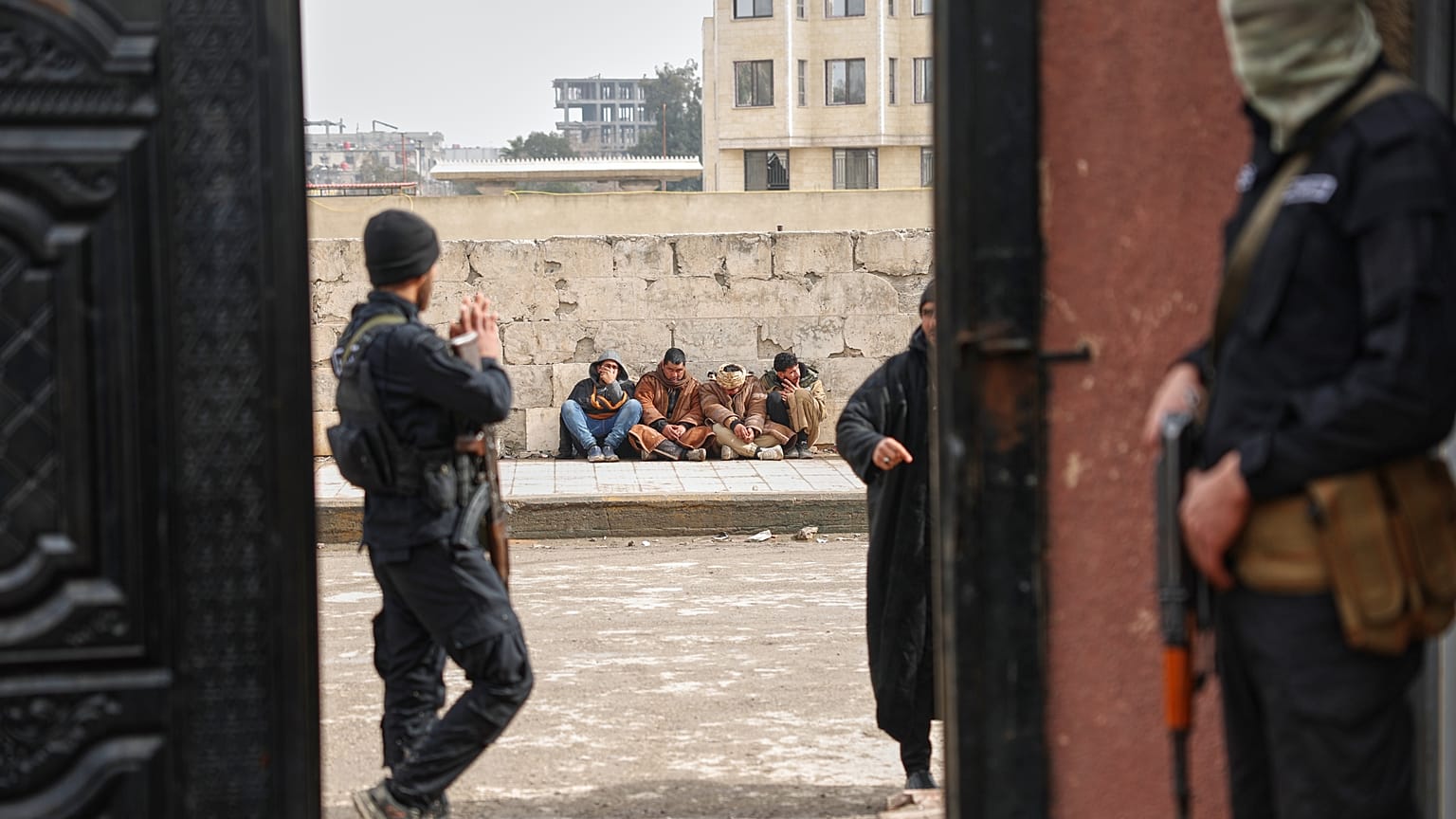 يجلس أعضاء سابقون في قوات سوريا الديمقراطية على الرصيف بانتظار تسجيل أسمائهم في مركز مصالحة تديره الحكومة للحصول على وثائق رسمية تثبت تركهم للجماعة وتجنب المزيد من الملاحقة ال