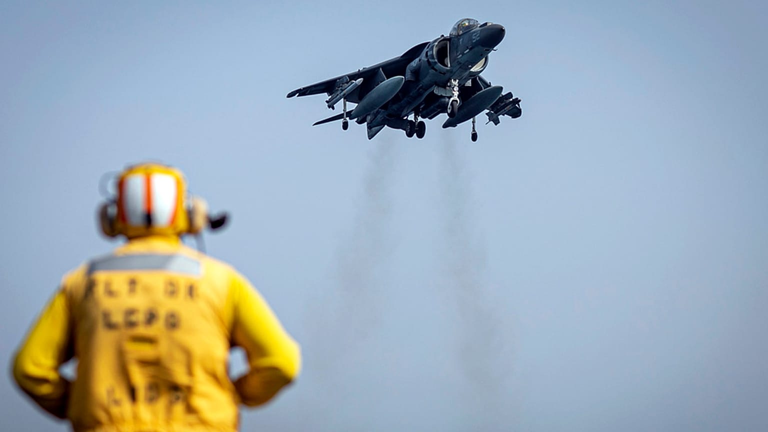 FILE: A sailor on the amphibious assault ship USS Bataan directs a Marine Corps AV-8B Harrier II jet in the Gulf of Oman, 14 August 2023