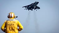 FILE: A sailor on the amphibious assault ship USS Bataan directs a Marine Corps AV-8B Harrier II jet in the Gulf of Oman, 14 August 2023