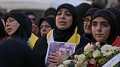 نساء ينحن خلال موكب جنازة ثلاثة مقاتلين من حزب الله قُتلوا في الغارات الإسرائيلية يوم الجمعة، في النبي شيت شرقي لبنان، السبت 21 فبراير/شباط 2026. 
