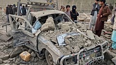 يقف سكان محليون بجانب سيارة تالفة في موقع غارة عسكرية باكستانية عبر الحدود في منطقة بيهسود بمحافظة ننغرهار في أفغانستان، يوم الأحد 22 فبراير 2026. (صور: AP / هداية شاه)