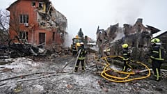Feuerwehrleute löschen ein Feuer, nachdem eine Drohne während eines russischen Luftangriffs in Kiew, Ukraine, am Sonntag, 22. Februar 2026, ein Wohngebäude getroffen hat.