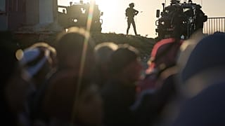 يقف جنود إسرائيليون على الحواجز بينما يصطف المصلون الفلسطينيون لعبور الحاجز العسكري قلنديا بين مدينة رام الله ومدينة القدس في طريقهم لأداء صلاة الجمعة في المسجد الأقصى