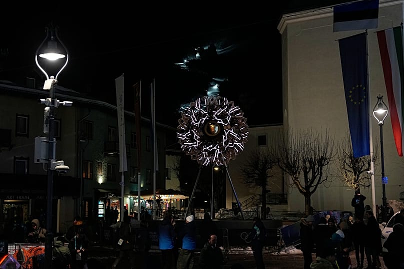 Pessoas se reúnem perto do caldeirão após ele ter sido apagado nos Jogos Olímpicos de Inverno de 2026, em Cortina d'Ampezzo, Itália, domingo, 22 de fevereiro de 2026.