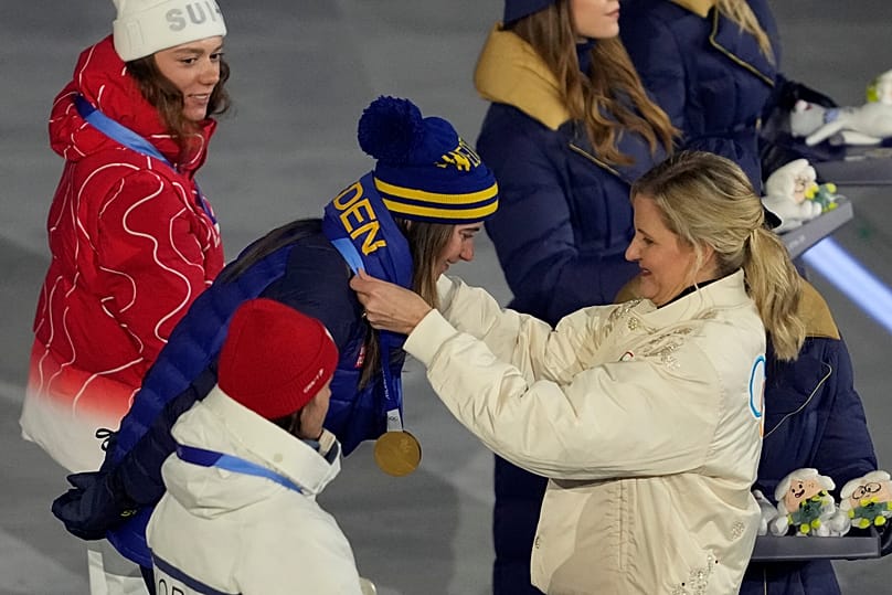 A presidente do COI, Kirsty Coventry, entrega a Ebba Andersson, da Suécia, a medalha de ouro na cerimónia de entrega de medalhas da prova feminina de esqui cross country 50 km