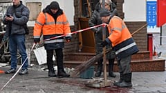 Städtische Mitarbeiter wischen Blutspuren weg an dem Ort, den die Behörden als Schauplatz eines Terrorangriffs im Zentrum von Lwiw bezeichnen.
