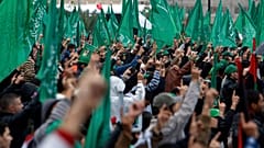 رفع نشطاء حركة حماس الفلسطينية أصابعهم وهم يهتفون بشعارات إسلامية بينما لوّح آخرون بالأعلام الإسلامية الخضراء، في مدينة غزة، السبت 8 ديسمبر/كانون الأول 2012. (صورة من وكالة أس