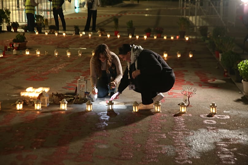 Κόσμος ανάβει κεράκια στο χώρο με τα ονόματα των 57 θυμάτων του σιδηροδρομικού δυστυχήματος στα Τέμπη