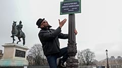 Der französische Künstler JR präsentiert am achtzehnten Februar zweitausendsechsundzwanzig auf der Pariser Pont Neuf ein Schild mit den Namen Christo und Jeanne-Claude.
