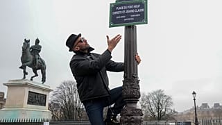 French artist JR shows a sign bearing the names of artists Christo and his partner Jeanne-Claude on the Pont Neuf bridge, in Paris, France, on Feb. 18, 2026