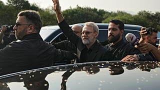 علي لاريجاني يلوّح لأنصار حزب الله لدى وصوله إلى مطار رفيق الحريري في بيروت، 13 أغسطس/آب 2025.