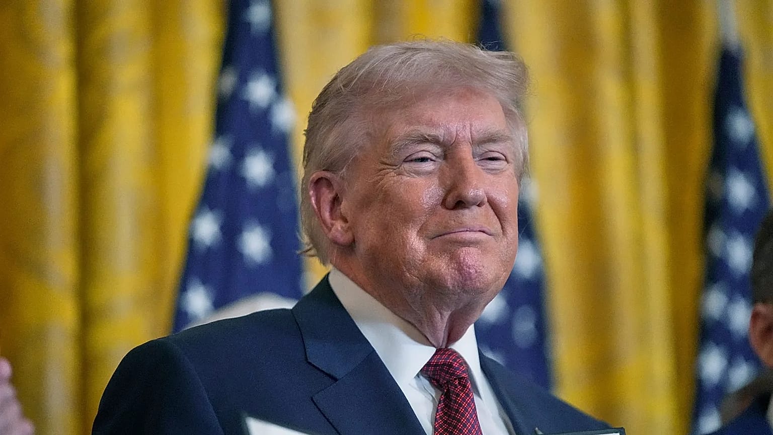 President Donald Trump holds up an executive order he just signed at the White House, Wednesday, Feb. 11, 2026, in Washington
