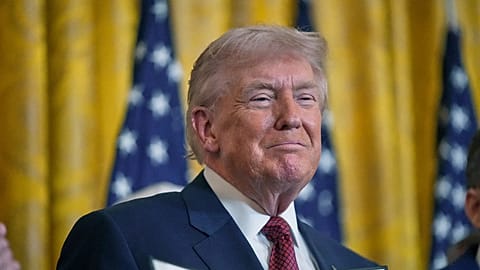 President Donald Trump holds up an executive order he just signed at the White House, Wednesday, Feb. 11, 2026, in Washington