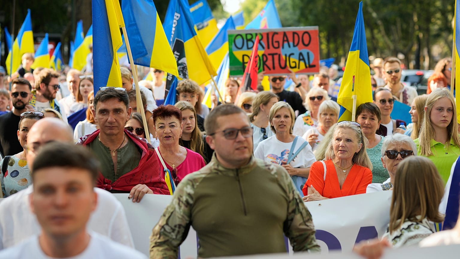 Pessoas com bandeiras ucranianas marcham pela Avenida da Liberdade, em Lisboa, durante uma manifestação para marcar o Dia da Independência da Ucrânia, 24 de agosto de 2025