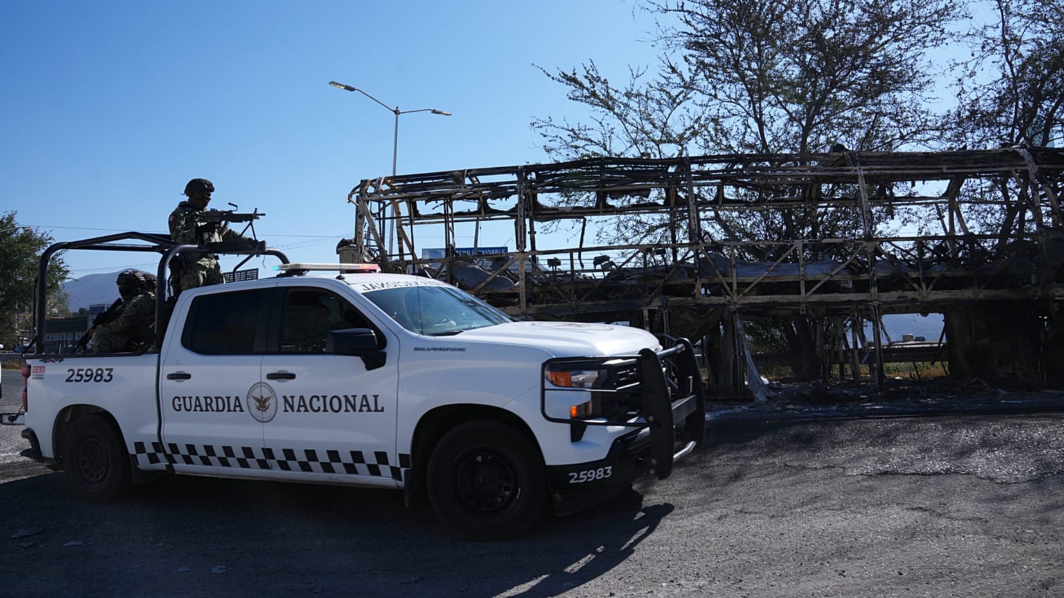 National Guard patrol past a charred vehicle the day after the Mexican army killed cartel leader Nemesio Oseguera Cervantes, in Guadalajara, Mexico, Monday, Feb. 23, 2026.
