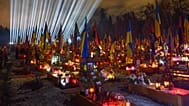 Floodlights shine over the graves of the fallen soldiers as people lit candles on the eve of the fourth anniversary of Russia's full-scale invasion in Lviv, Feb. 23, 2026.