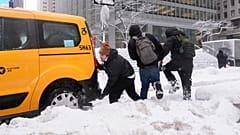 Ein Taxi bleibt im Schneesturm im Schnee stecken.