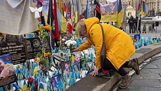 Frauen legen Blumen am Denkmal für die gefallenen ukrainischen Soldaten auf dem Unabhängigkeitsplatz anlässlich des vierten Jahrestages des Krieges in Kiew, Ukraine, Dienstag, 24. Februar 2026