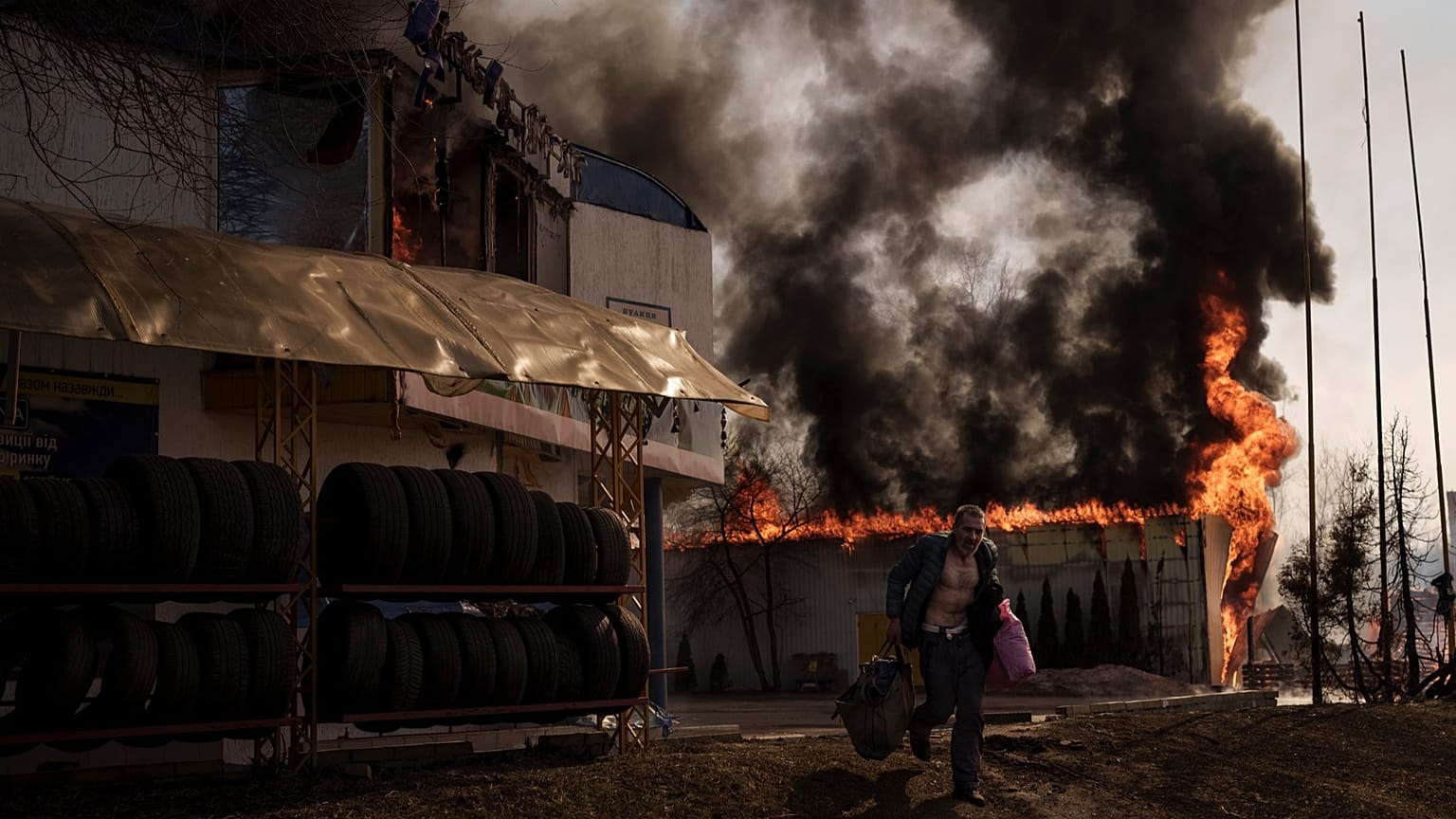 A man recovers items from a shop that caught fire in a Russian attack in Kharkiv, Ukraine, Friday, March 25, 2022.