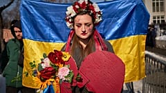 Eine Frau trägt bei einer Mobilisierung in Bukarest einen Blumenkranz (Illustration)