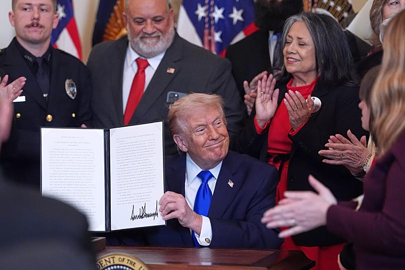 الرئيس الأمريكي دونالد ترامب يحمل إعلانًا موقعًا يحدد يوم 22 فبراير كيوم "عائلات الملائكة" خلال فعالية في الغرفة الشرقية بالبيت الأبيض