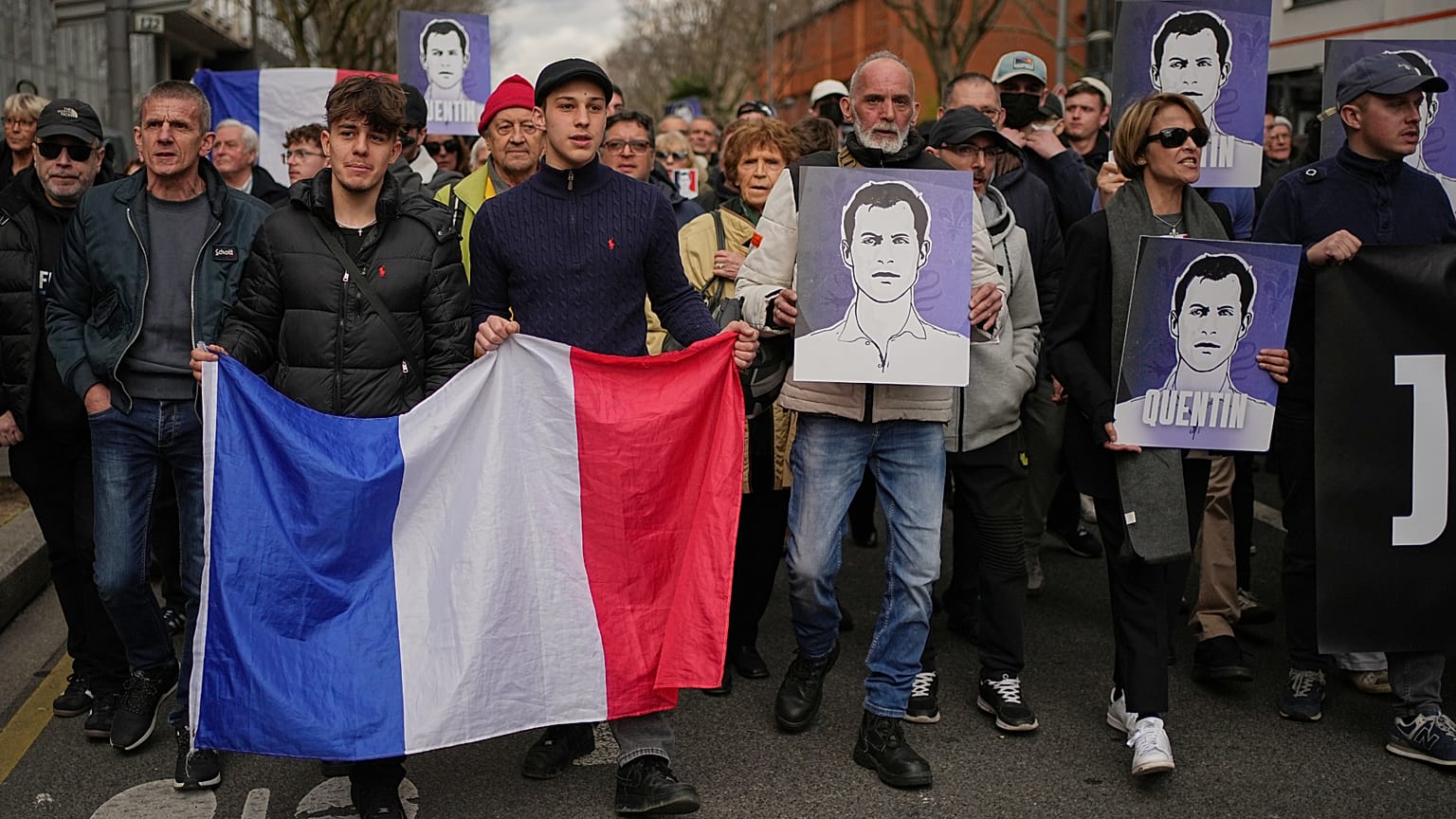 Des personnes participent à une marche avec des drapeaux nationaux français et des portraits de l'étudiant assassiné à Lyon, en France, samedi 21 février.