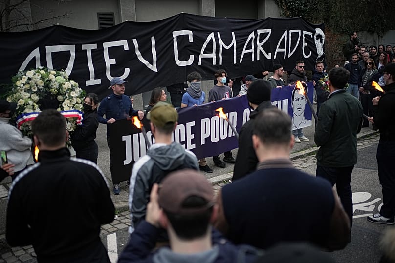 Des personnes brandissent une banderole sur laquelle on peut lire « Au revoir camarade » lors d'une marche organisée à Lyon, en France, le samedi 21 février 2026, afin de rend